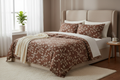 Cocoa brown and ivory leaf print bedsheet set styled on a neatly made bed with warm natural lighting