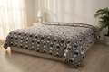 Comforter with ogee leaf print draped on a bed in a cozy bedroom